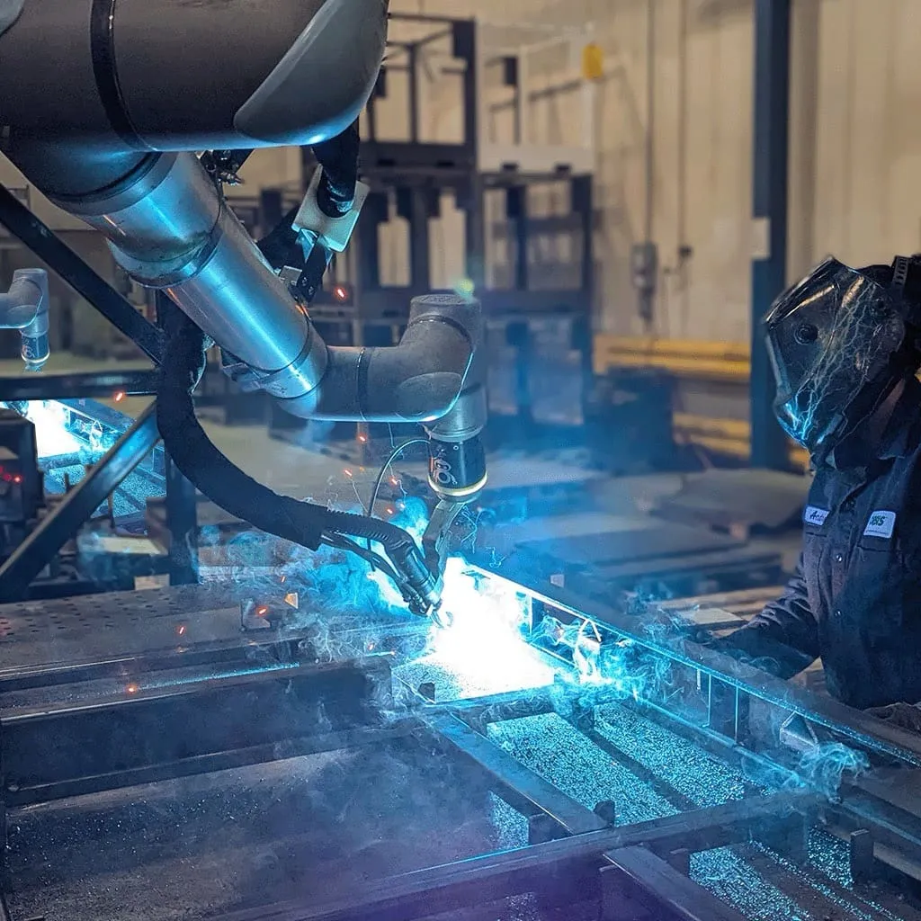 A welder running multiple cobots in a small fabrication shop