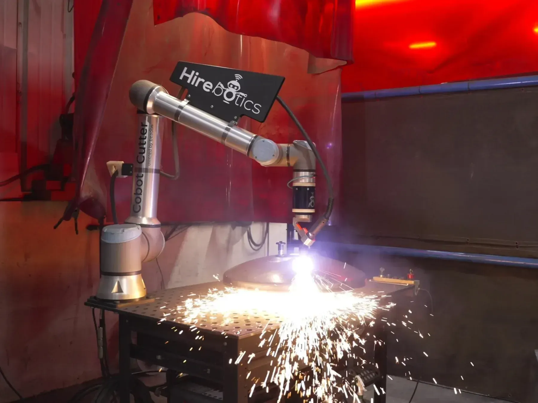 Cobot Cutter plasma-cutting a tank head on its mobile cart