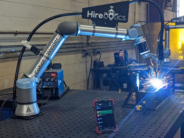 Cobot Welder running a live MIG weld, programmed from the tablet on the table