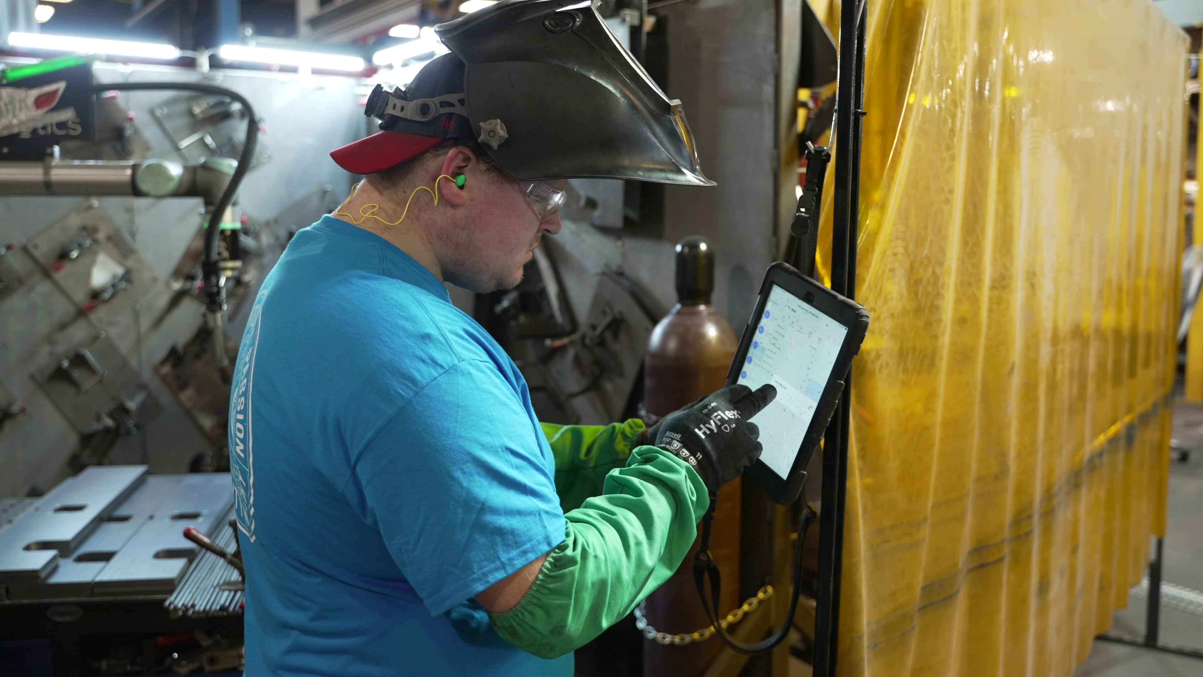 a robotic welder operator programming a welding cobot through an app