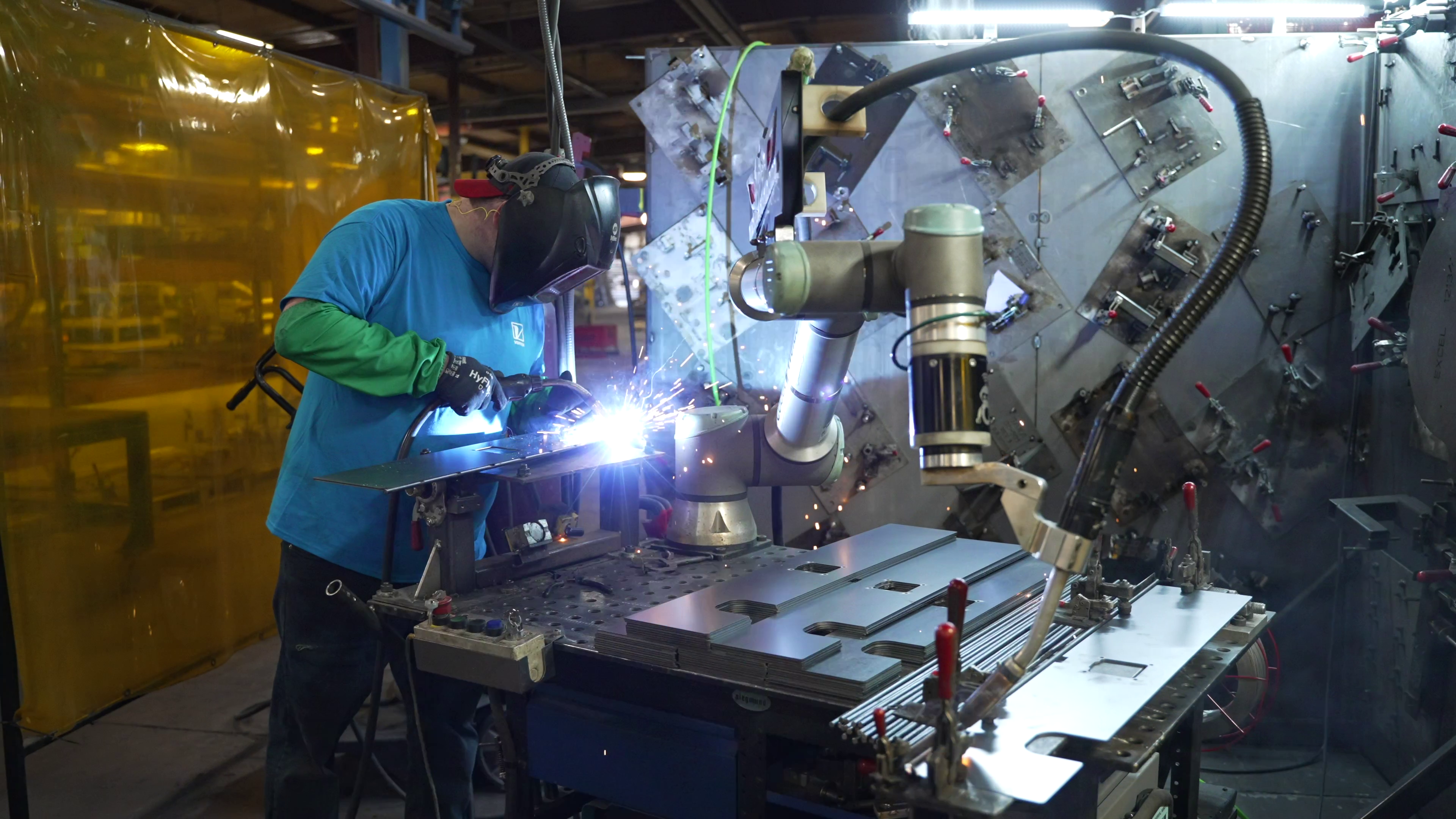 A robotic welder operator in action beside a collaborative welding robot